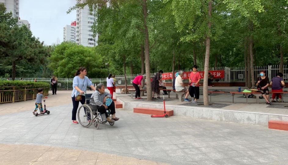 图 乘坐轮椅的老人在银杏广场前通过.jpg