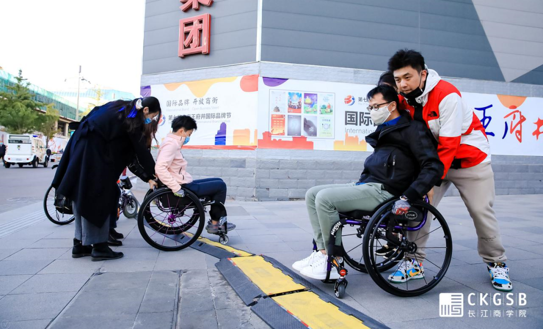 同学们在步行街用轮椅跨越障碍.png